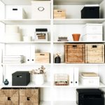 White shelving unit with various storage boxes. Title is How to Choose Storage Bins for your Home Office for a remote worker.