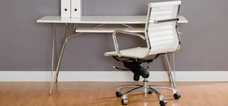 Minimalist home office setup with white office chair, desk and files. 
