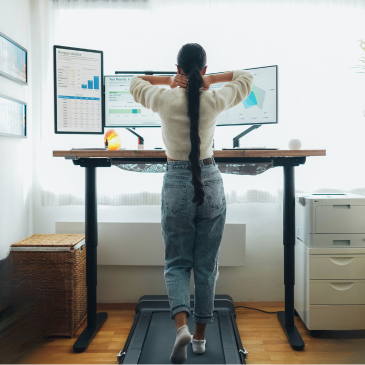 woman walking on walking pad at standing desk while working